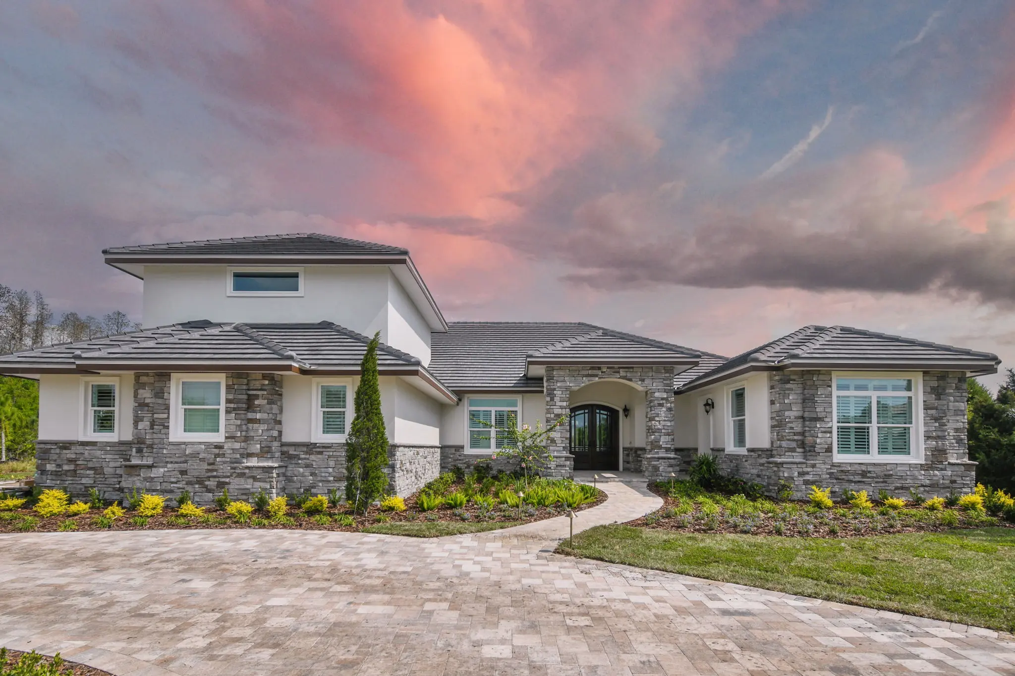 A large house with a driveway and lots of landscaping.