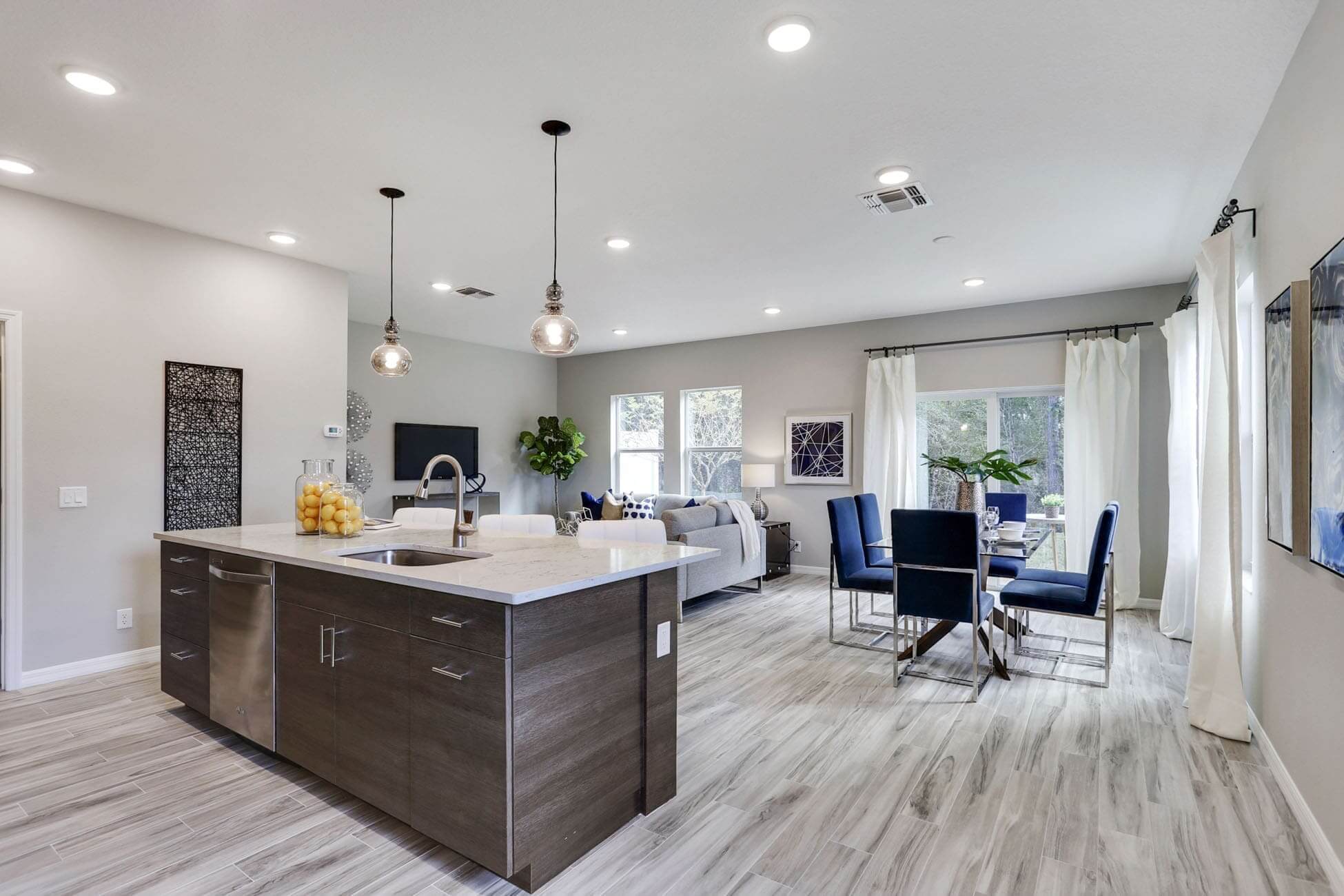 Modern kitchen and living area with dining table.